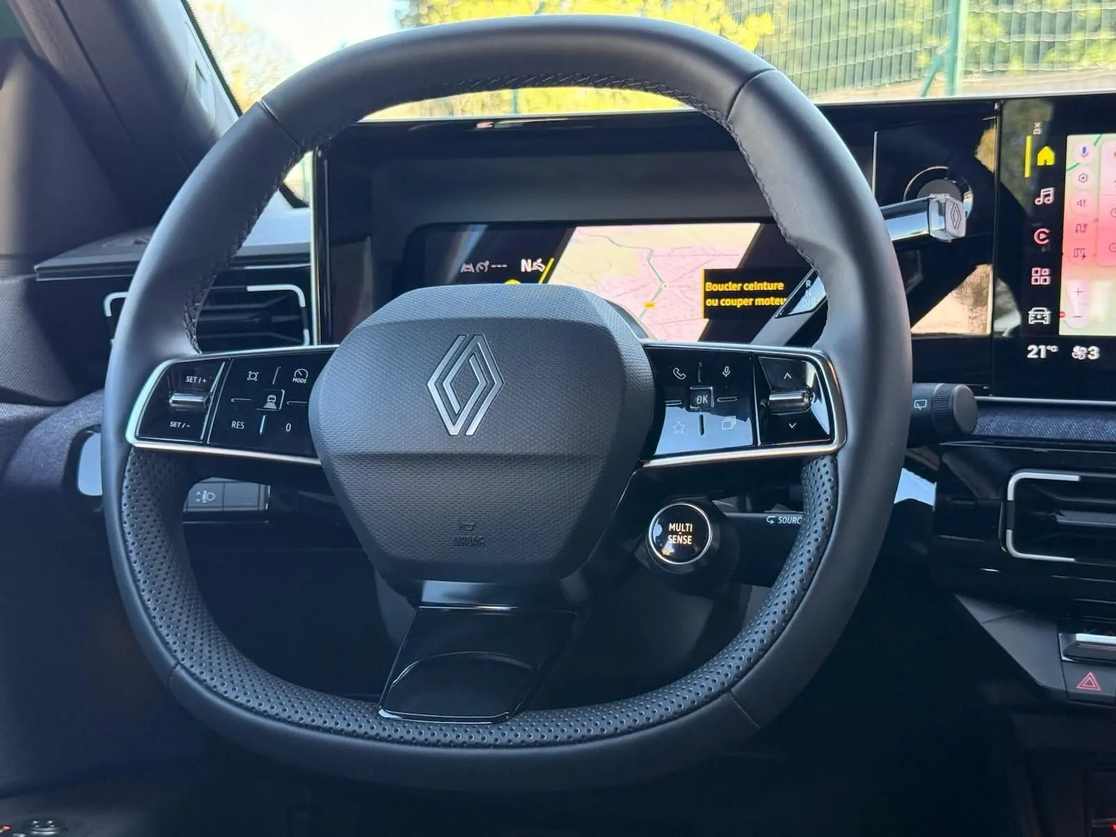 Vue rapprochée du volant noir perforé de la Renault R5 E-TECH 100% électrique avec tableau de bord numérique visible.