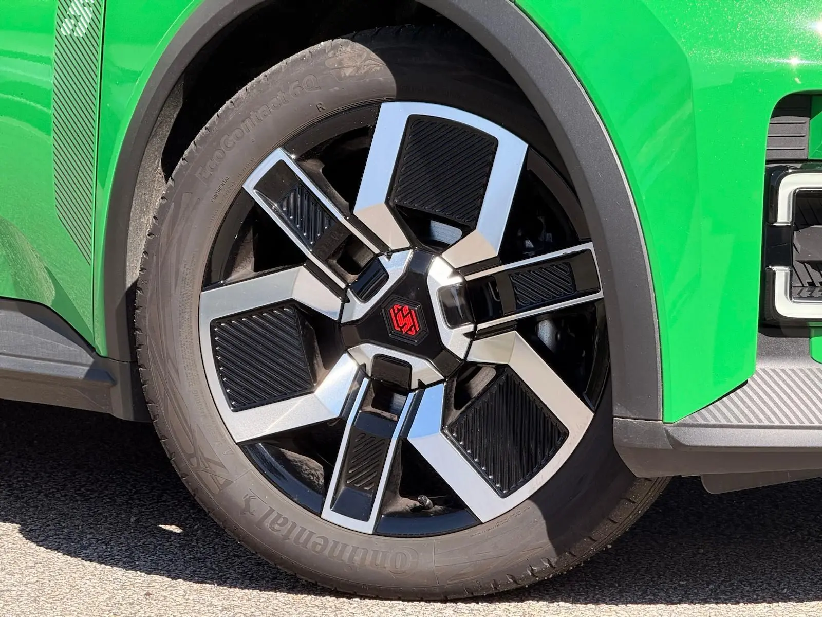 Gros plan sur la roue avant droite de la Renault R5 E-TECH 100% électrique en vert Pop avec jante bi-ton noire et argent.