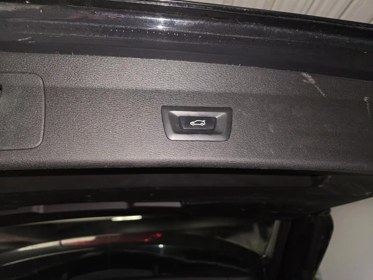 Bouton d'ouverture électrique du hayon sur l'intérieur du coffre d'un BMW X1 noir xDrive 25d F48 xLine 2016.