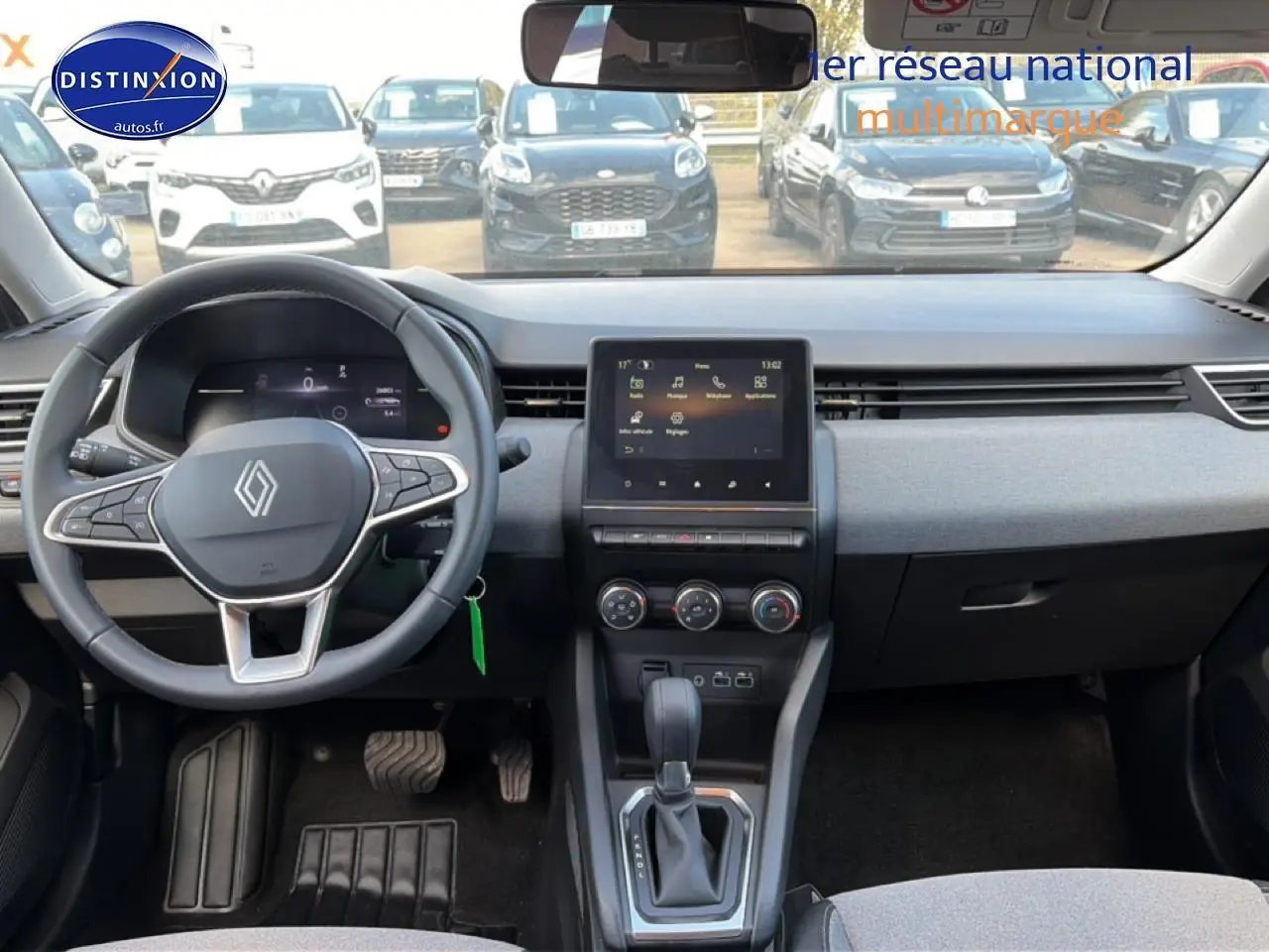 Intérieur de Renault Clio V gris foncé, vue frontale du tableau de bord avec écran tactile et volant multifonction.