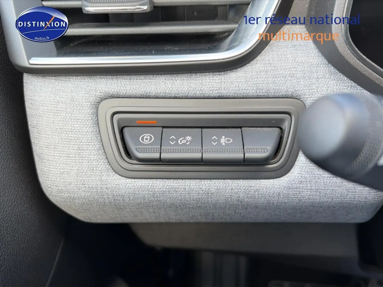 Détail des commandes d’éclairage et verrouillage sur tableau de bord gris clair de Renault Clio V 2025.