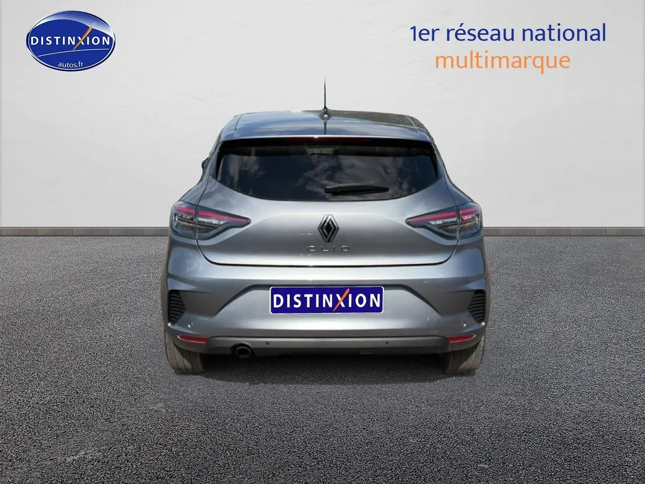 Vue arrière d'une Renault Clio V gris foncé avec feux LED et lunette arrière teintée sur sol goudronné.