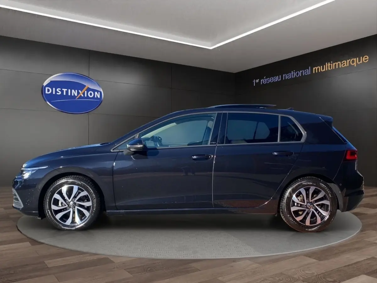 Vue de profil côté gauche d'une Volkswagen Golf noire 5 portes, avec jantes alliage et toit panoramique visible.
