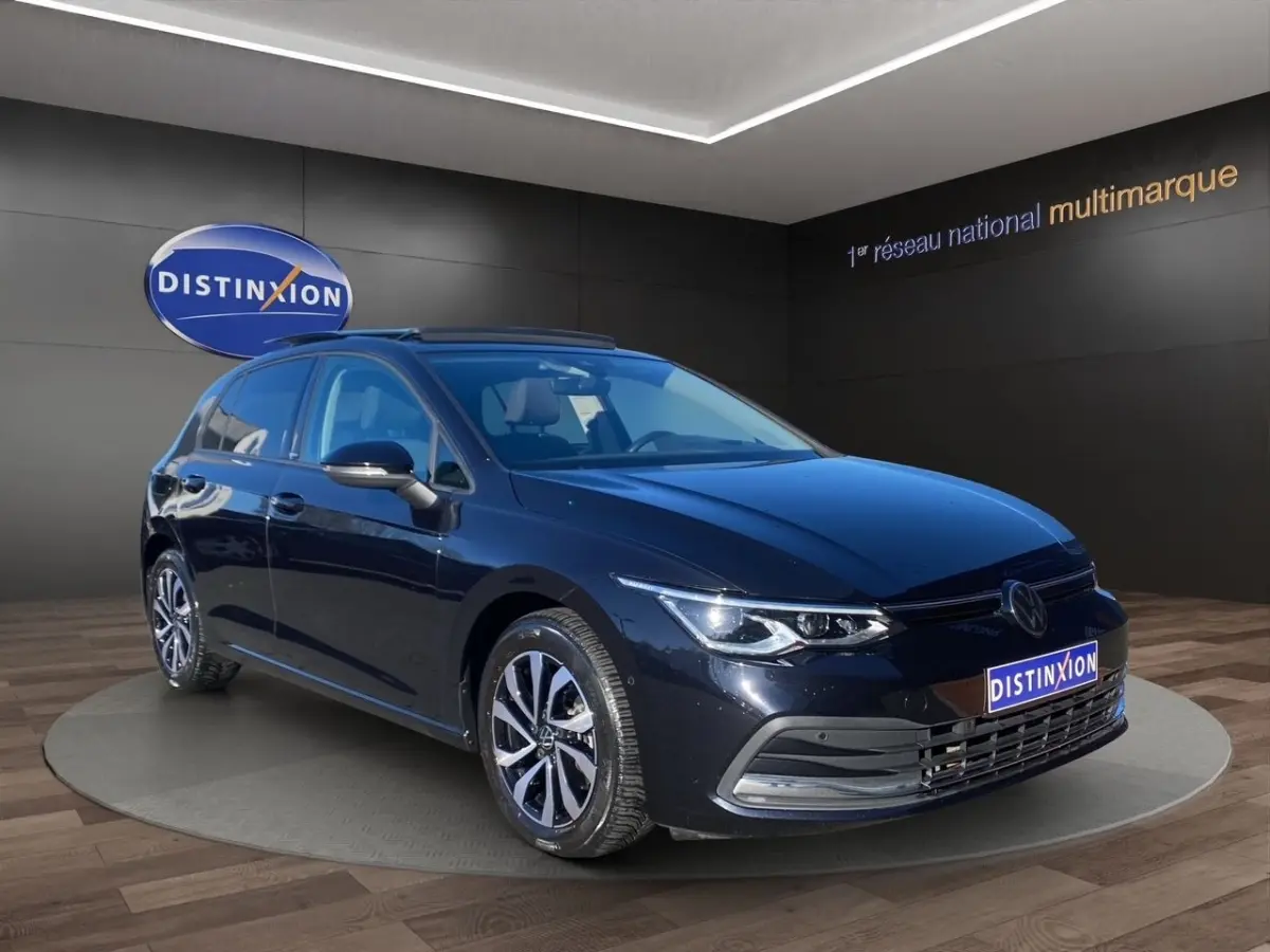 Volkswagen Golf noire vue en 3/4 avant droit, avec toit panoramique et jantes alliage distinctives.