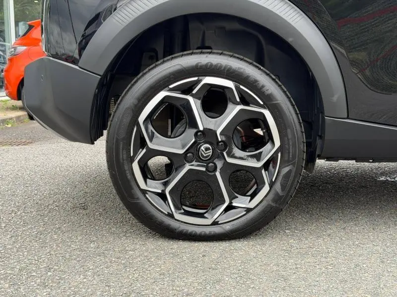 Gros plan sur la roue arrière droite de la Citroën C3 1.2 Turbo 2025 en Noir Perla Nera avec jante alu au design hexagonal.