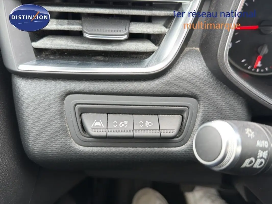 Gros plan sur les commandes d'assistance à la conduite à gauche du volant dans une Renault Clio blanche 2021.