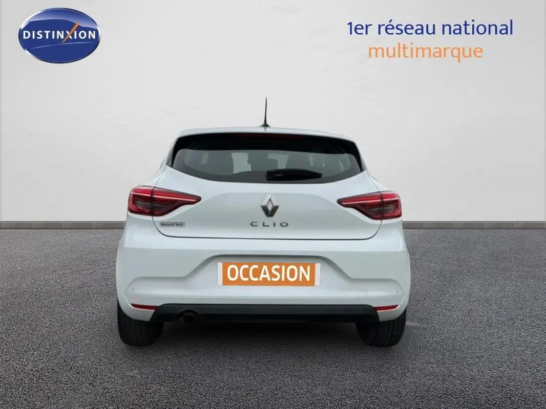 Vue arrière d'une Renault Clio blanche 2021, avec feux arrière allumés et plaque "OCCASION" visible.
