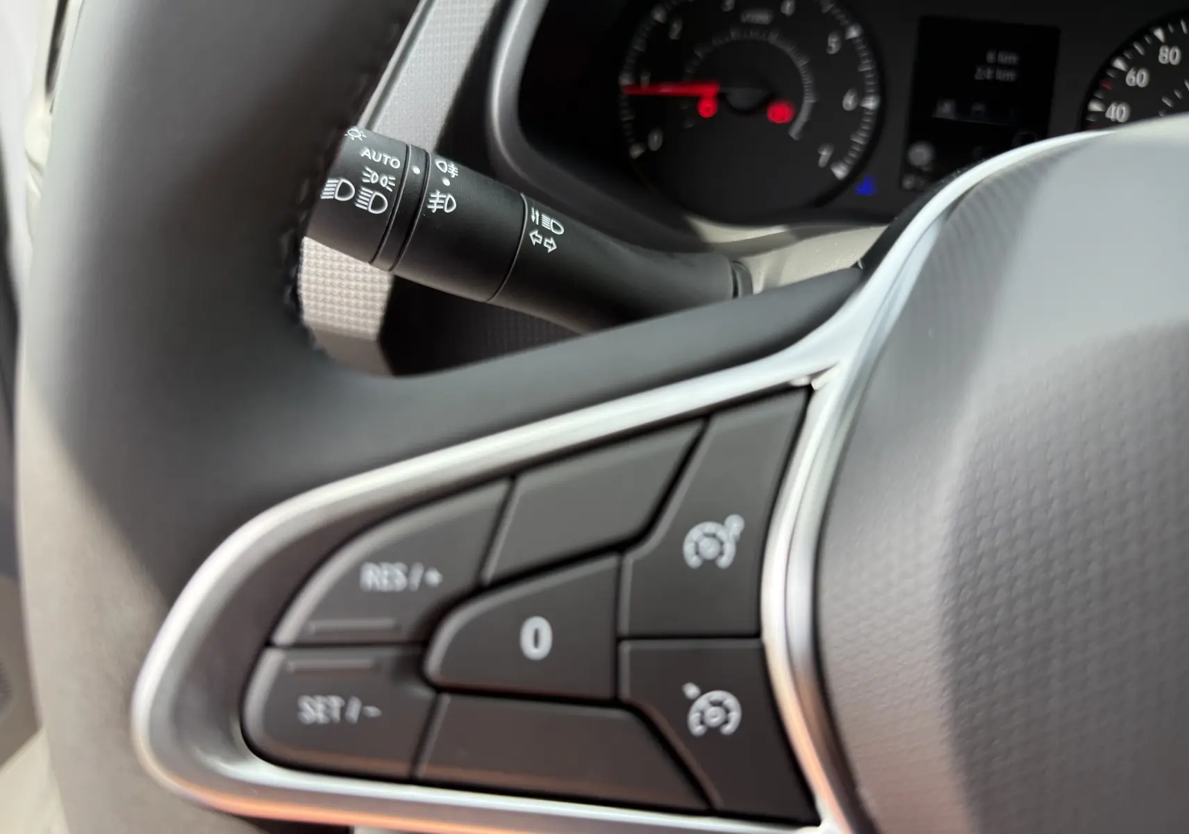 Gros plan sur les commandes au volant du Renault Trafic Fourgon blanc, avec tableau de bord partiellement visible en arrière-plan.
