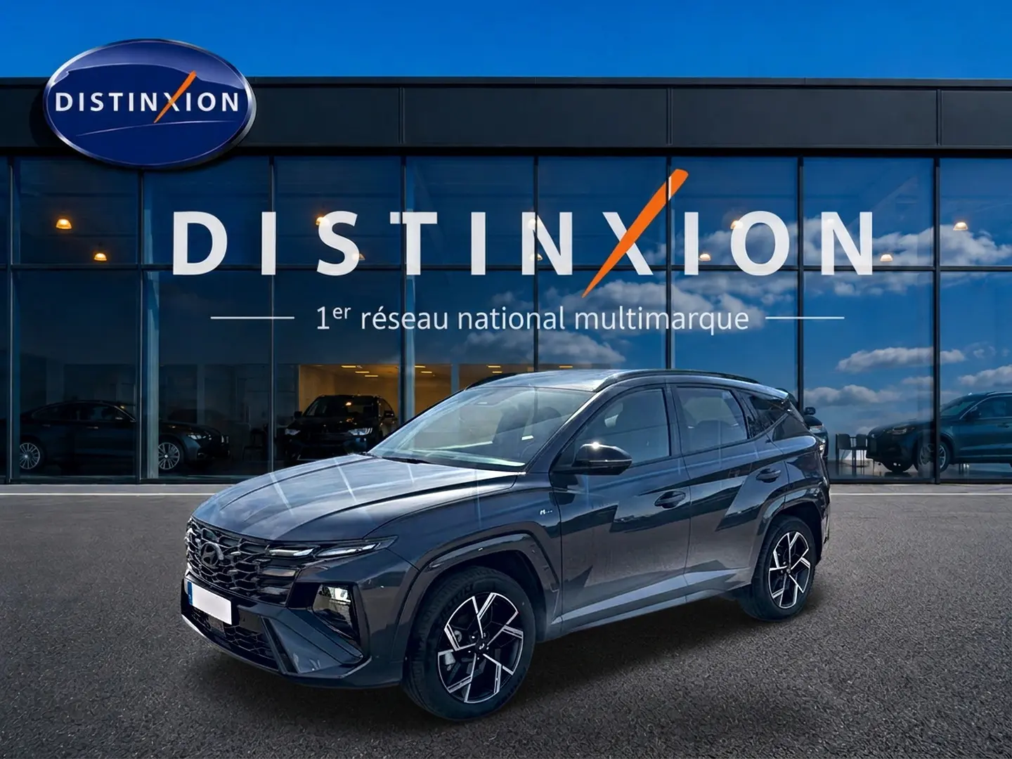 Hyundai Tucson 1.6 T-GDI hybride gris écotronique en 3/4 avant, avec jantes alliage 19 pouces et calandre glossy noire.