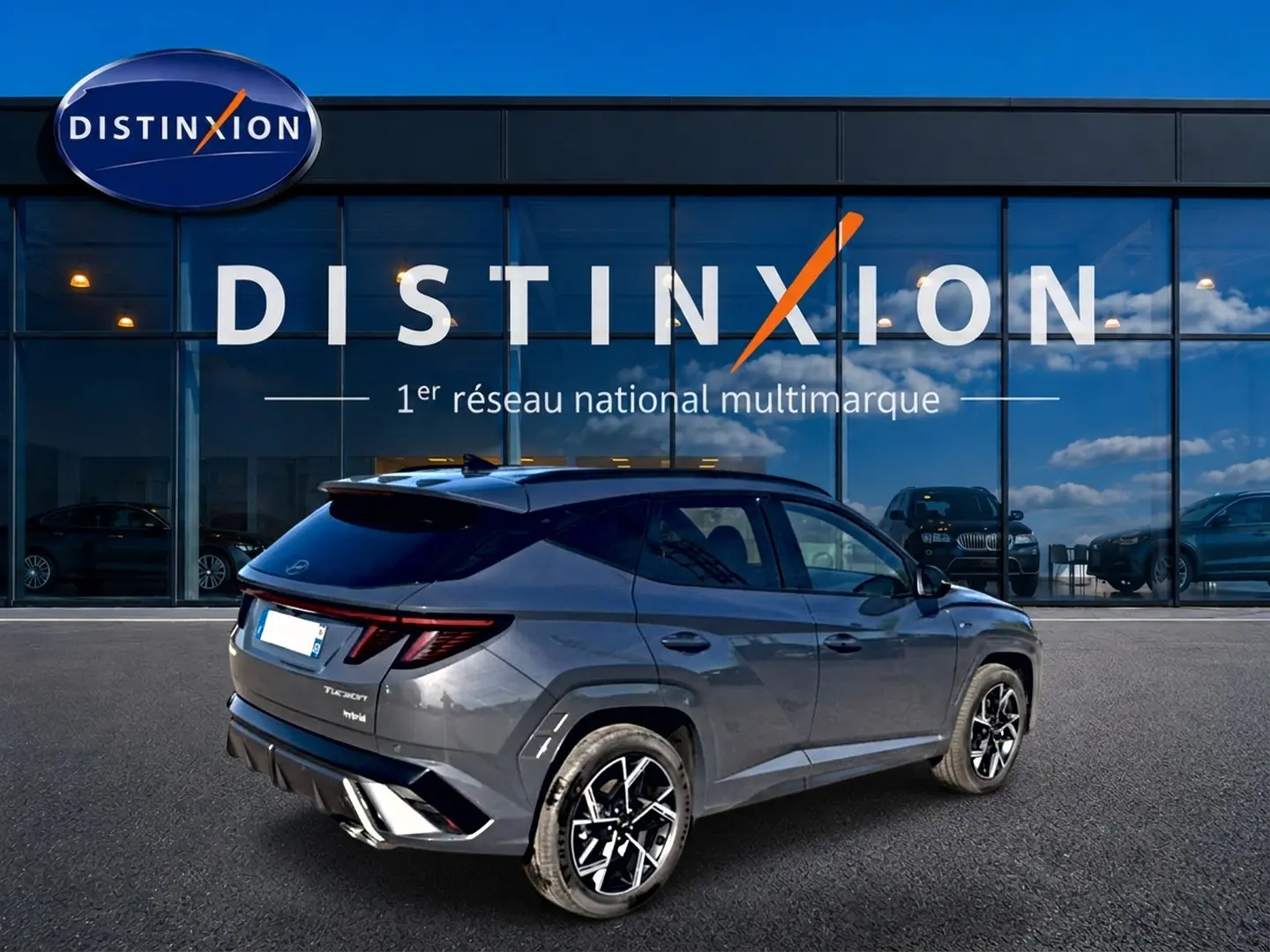 Vue 3/4 arrière droite du Hyundai Tucson 2026 gris ecotronique avec jantes alliage et toit noir contrasté.
