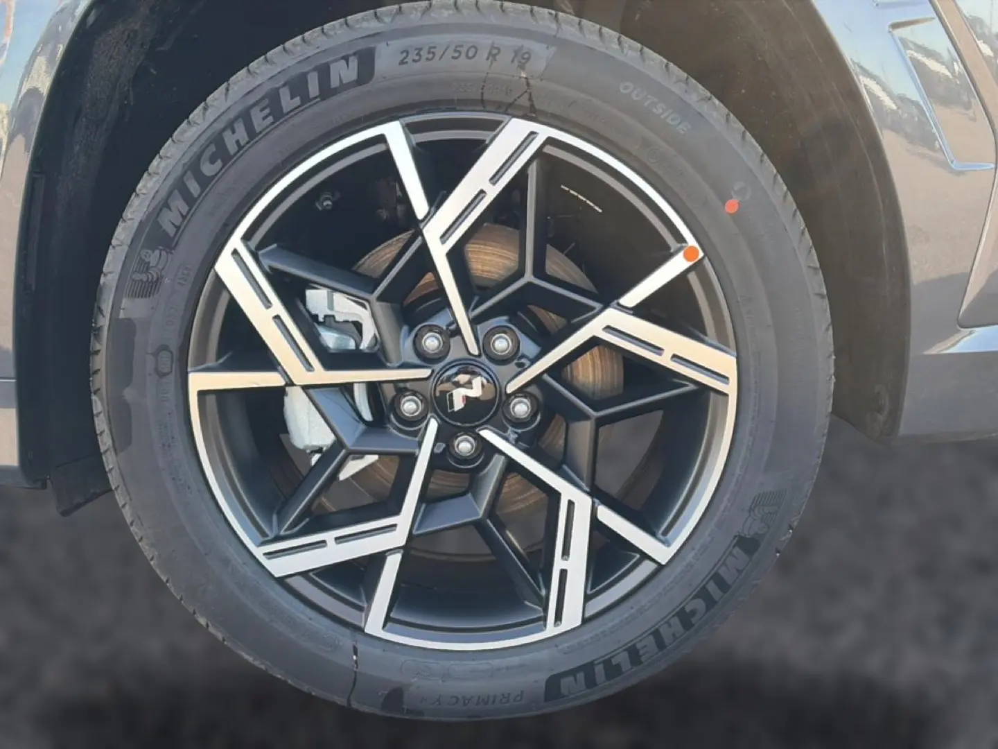 Gros plan sur la jante alliage 19 pouces noire et argentée du Hyundai Tucson gris ecotronique, version N Line.