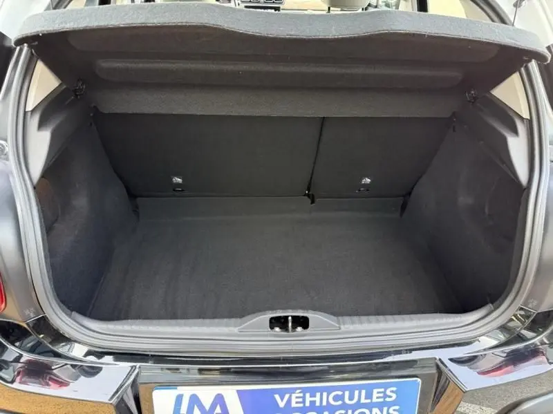 Coffre ouvert en vue arrière d'une Citroën C3 noire avec toit blanc, montrant l'espace de rangement vide.