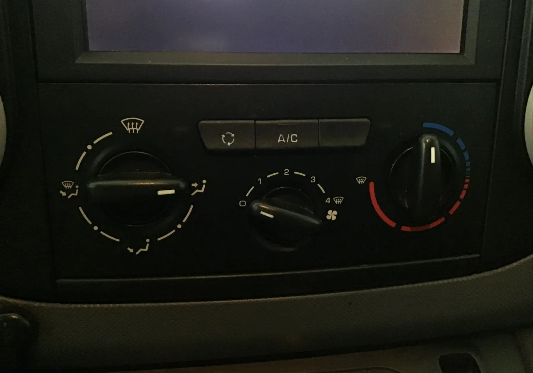 Gros plan sur les commandes de climatisation du Citroën Berlingo blanc, version Business 2018, avec boutons rotatifs et affichage A/C.