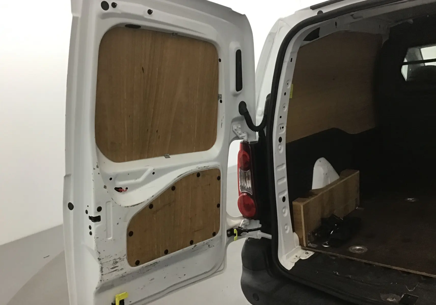 Vue arrière droite du Citroën Berlingo blanc 2018 avec porte ouverte montrant l'intérieur boisé du coffre utilitaire.