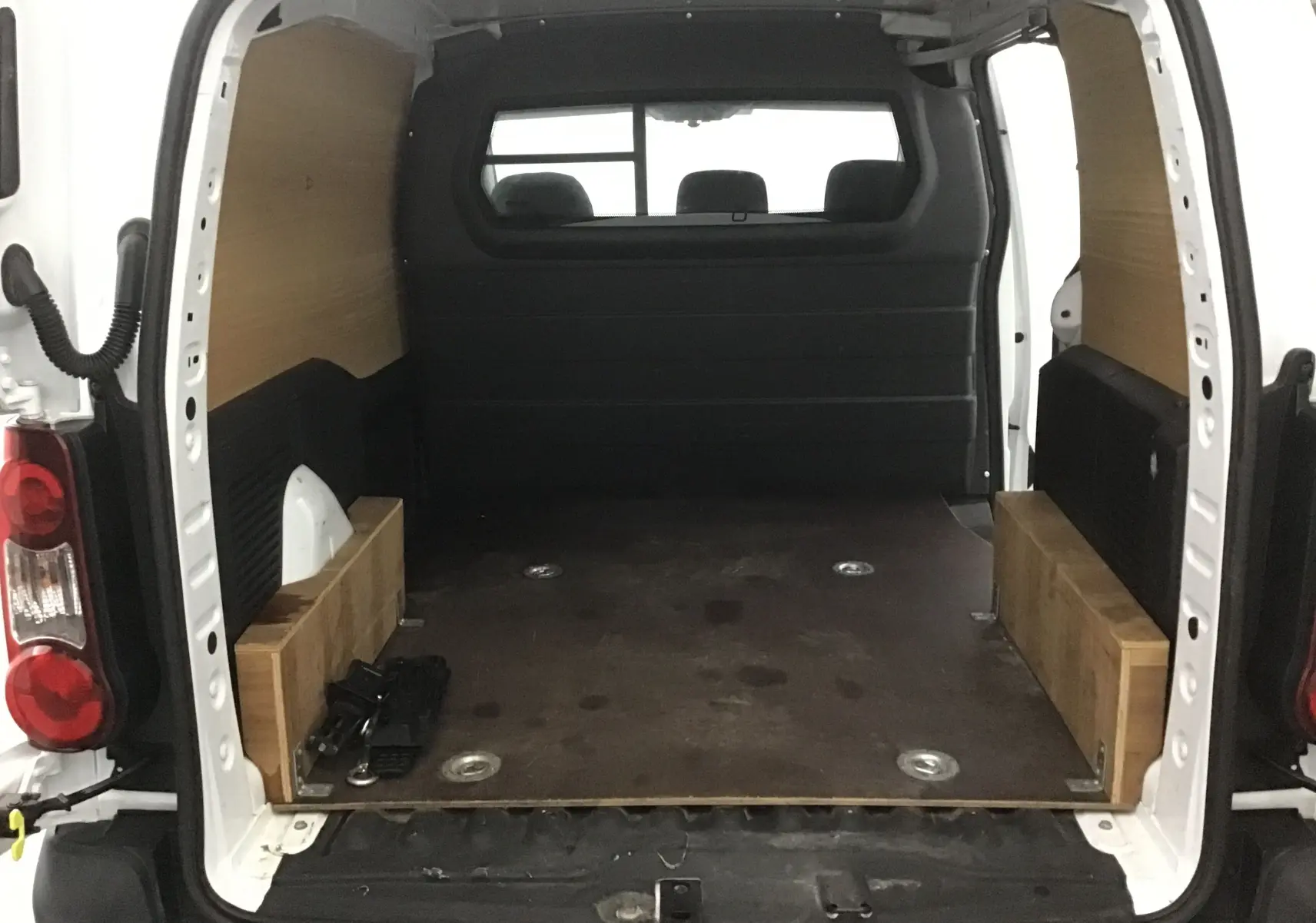 Vue arrière ouverte du Citroën Berlingo blanc 2018 avec espace de chargement boisé et plancher sombre.