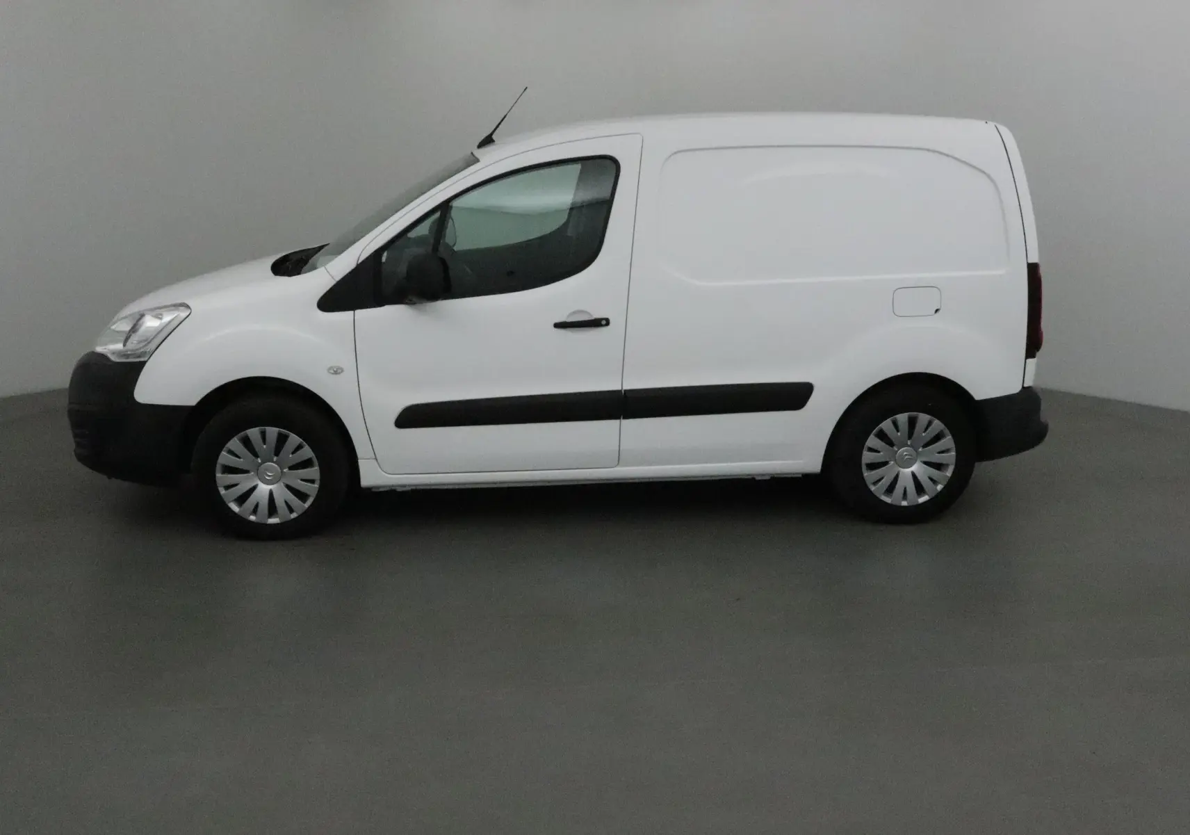 Profil côté gauche d'un utilitaire blanc Citroën Berlingo 2018 avec bande noire latérale et jantes acier.