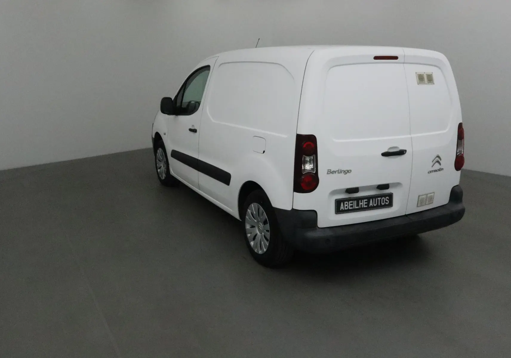 Vue 3/4 arrière droite d’un utilitaire blanc Citroën Berlingo 2018 avec portes arrière battantes et logo visible