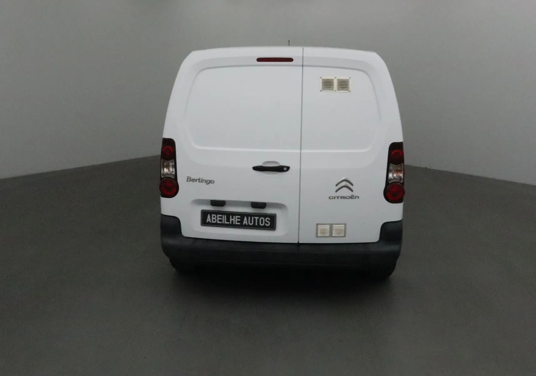 Vue arrière d'un utilitaire blanc Citroën Berlingo 2018 avec portes battantes et logo visible sur fond neutre.