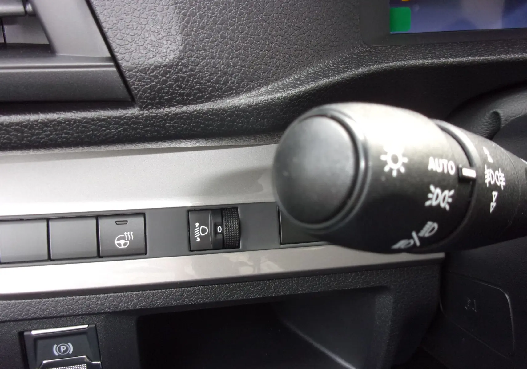 Gros plan sur la commande des phares et des réglages lumineux du tableau de bord du Citroën Jumpy XL noir Perla.