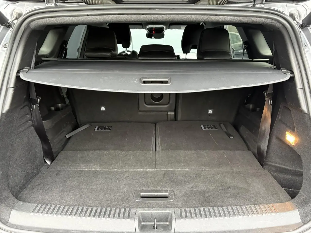 Vue arrière du coffre ouvert du Renault Espace gris schiste, montrant les sièges rabattus et la plage arrière.