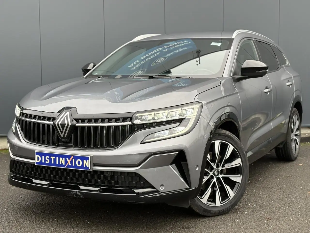 Renault Espace gris schiste en vue 3/4 avant droit, avec jantes alliage noires et calandre marquée.