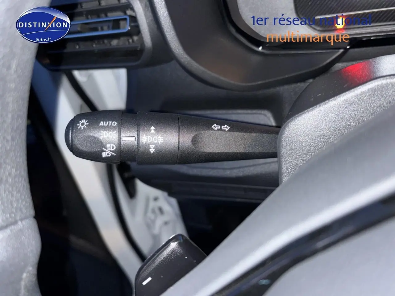 Gros plan sur la commande des phares et clignotants côté gauche du volant d’un Citroën Berlingo Fourgon blanc.