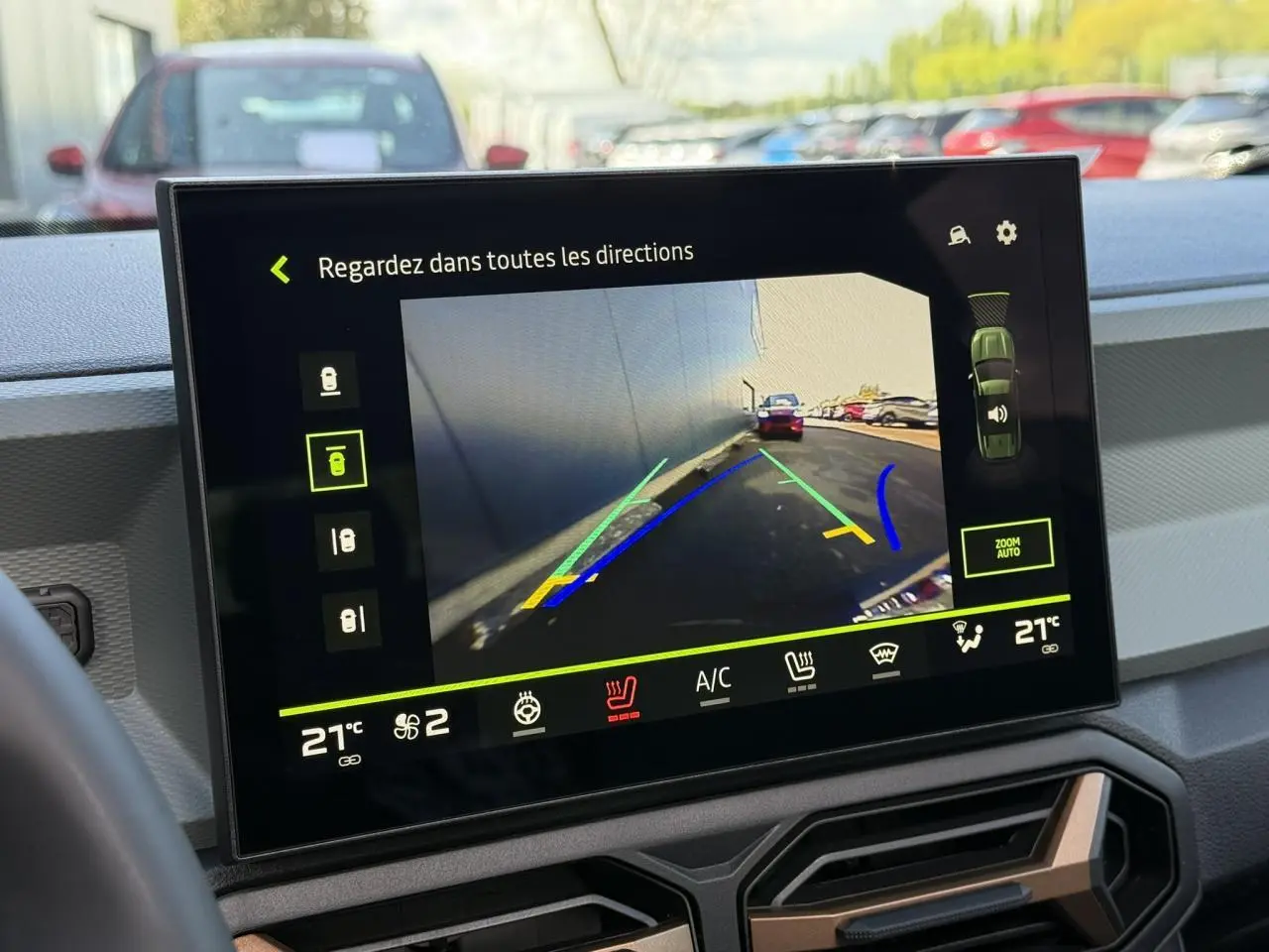 Écran tactile intérieur montrant la caméra multivues en marche, avec vue arrière et lignes de guidage colorées.