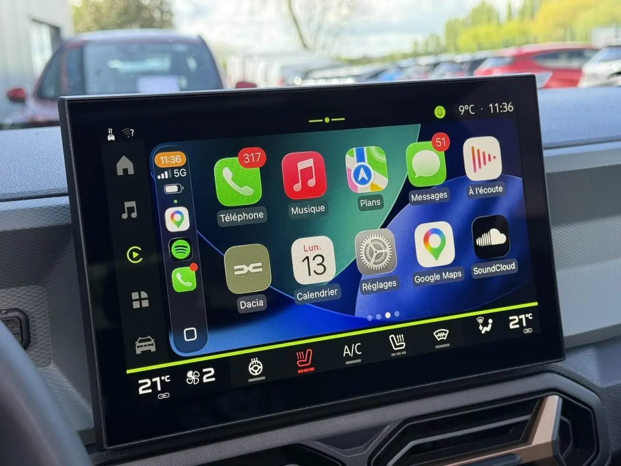 Écran tactile central du tableau de bord du Dacia Bigster affichant Apple CarPlay et commandes climatisation à 21°C.