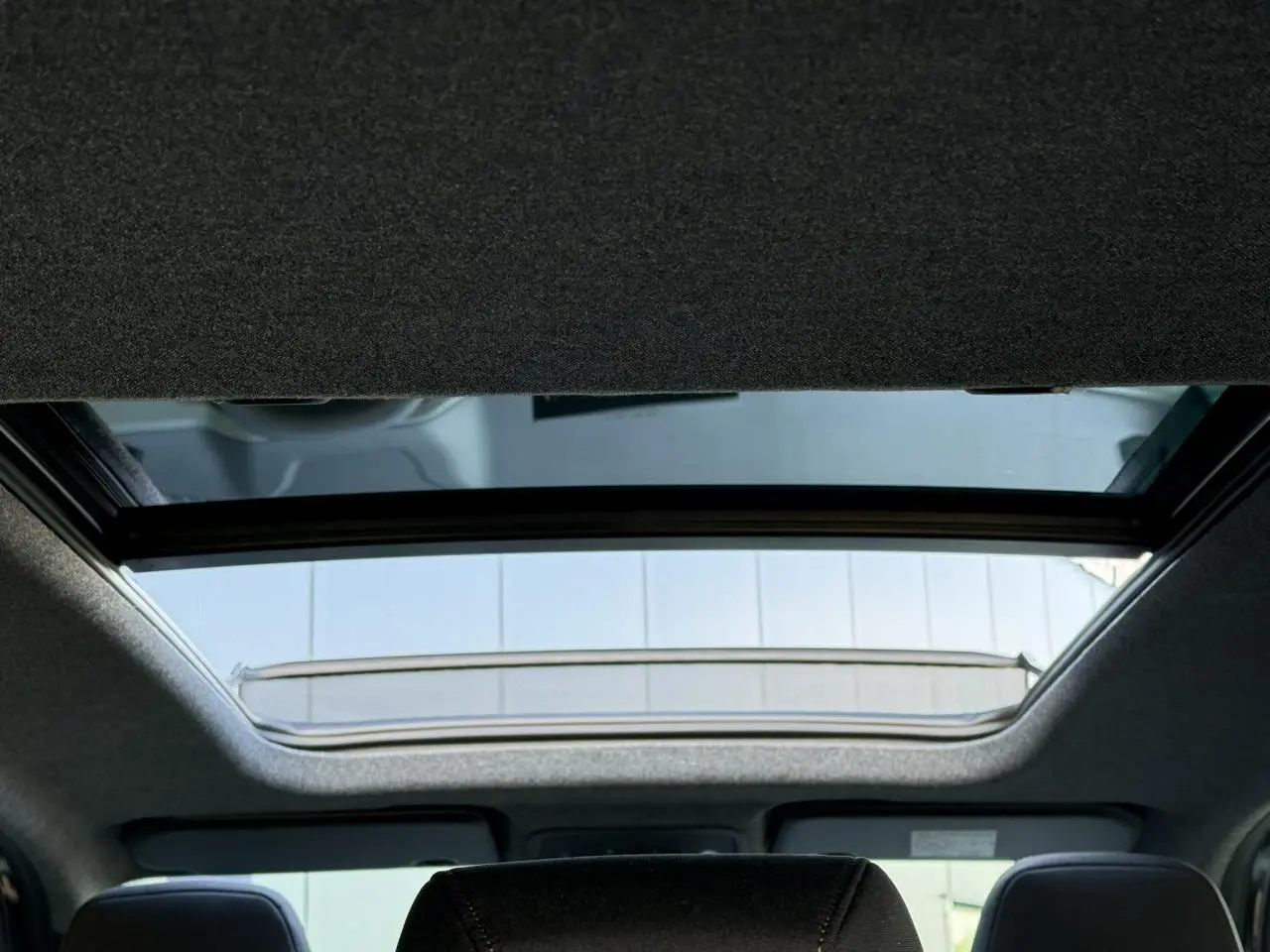 Vue intérieure du toit ouvrant panoramique du Dacia Bigster 2026, avec ciel visible à travers la vitre.