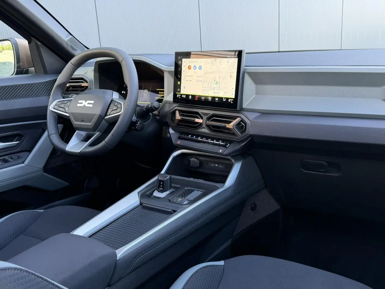 Vue intérieure côté conducteur du tableau de bord et console centrale du Dacia Bigster 2026, avec écran tactile et volant multifonction.