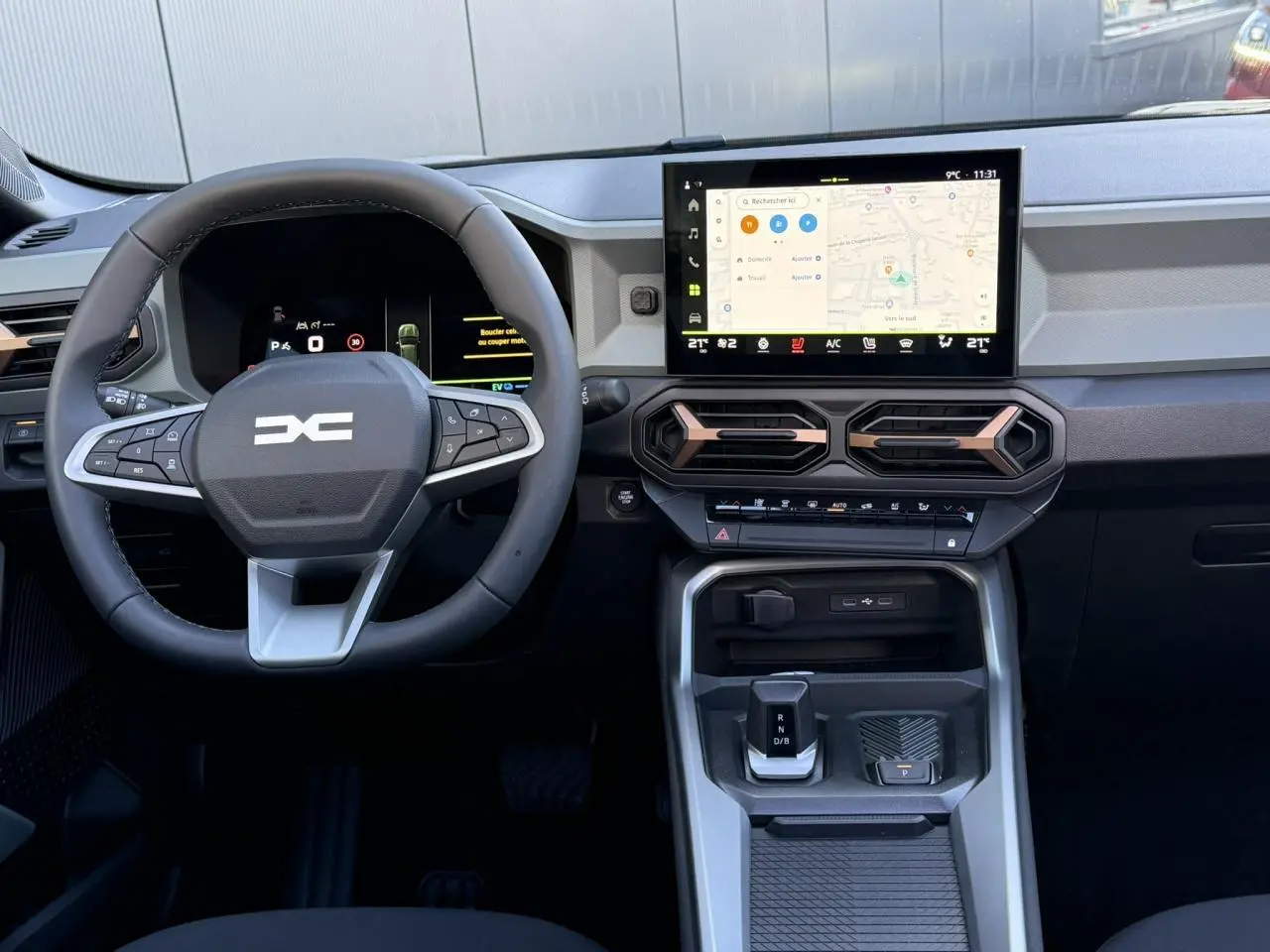 Vue intérieure frontale du tableau de bord du Dacia Bigster 2026 avec écran tactile et volant multifonction noir.