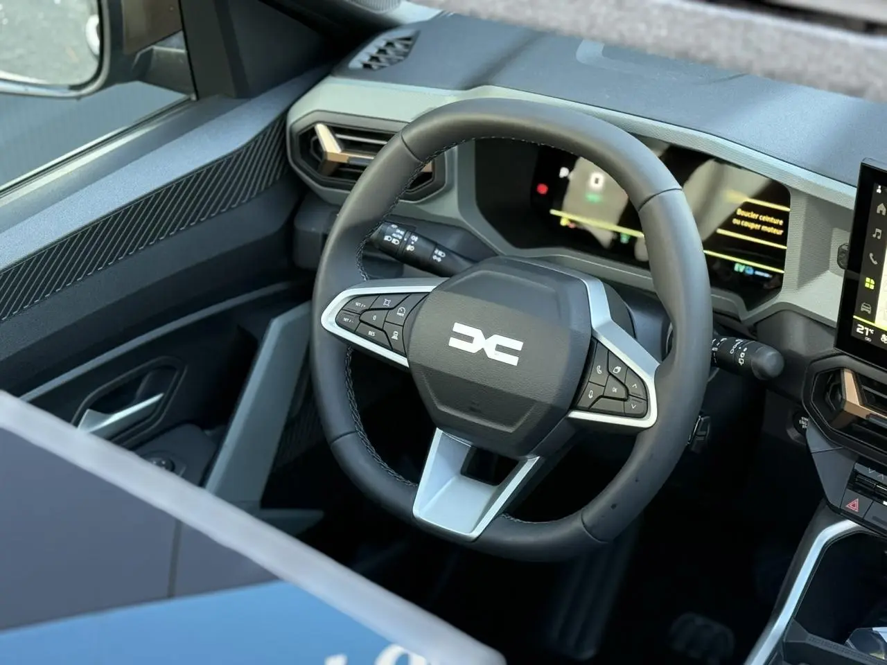 Vue rapprochée du volant multifonction noir avec logo DACIA blanc, tableau de bord numérique et partie de la console centrale du Dacia Bigster 2026.