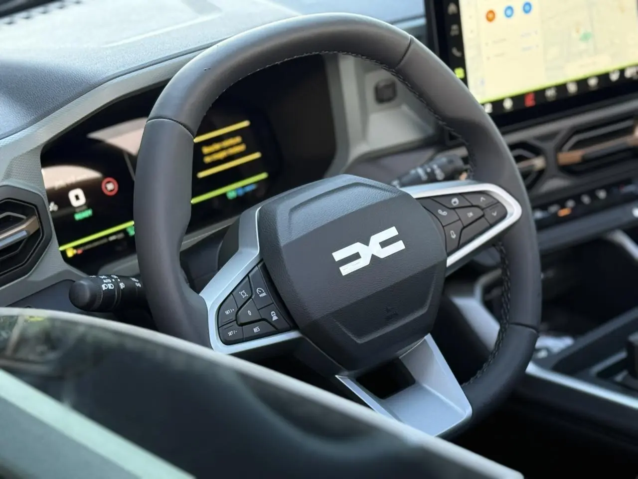 Vue rapprochée du volant noir et gris du Dacia Bigster 2026 avec tableau de bord numérique et écran tactile.