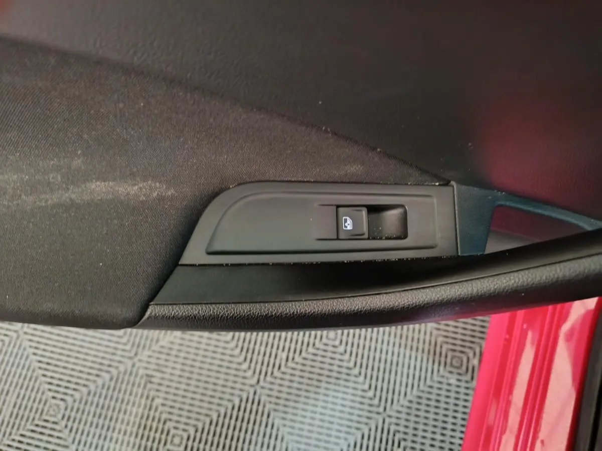 Bouton de verrouillage des portes sur la portière côté conducteur d’un SKODA KAMIQ rouge, vue intérieure rapprochée.