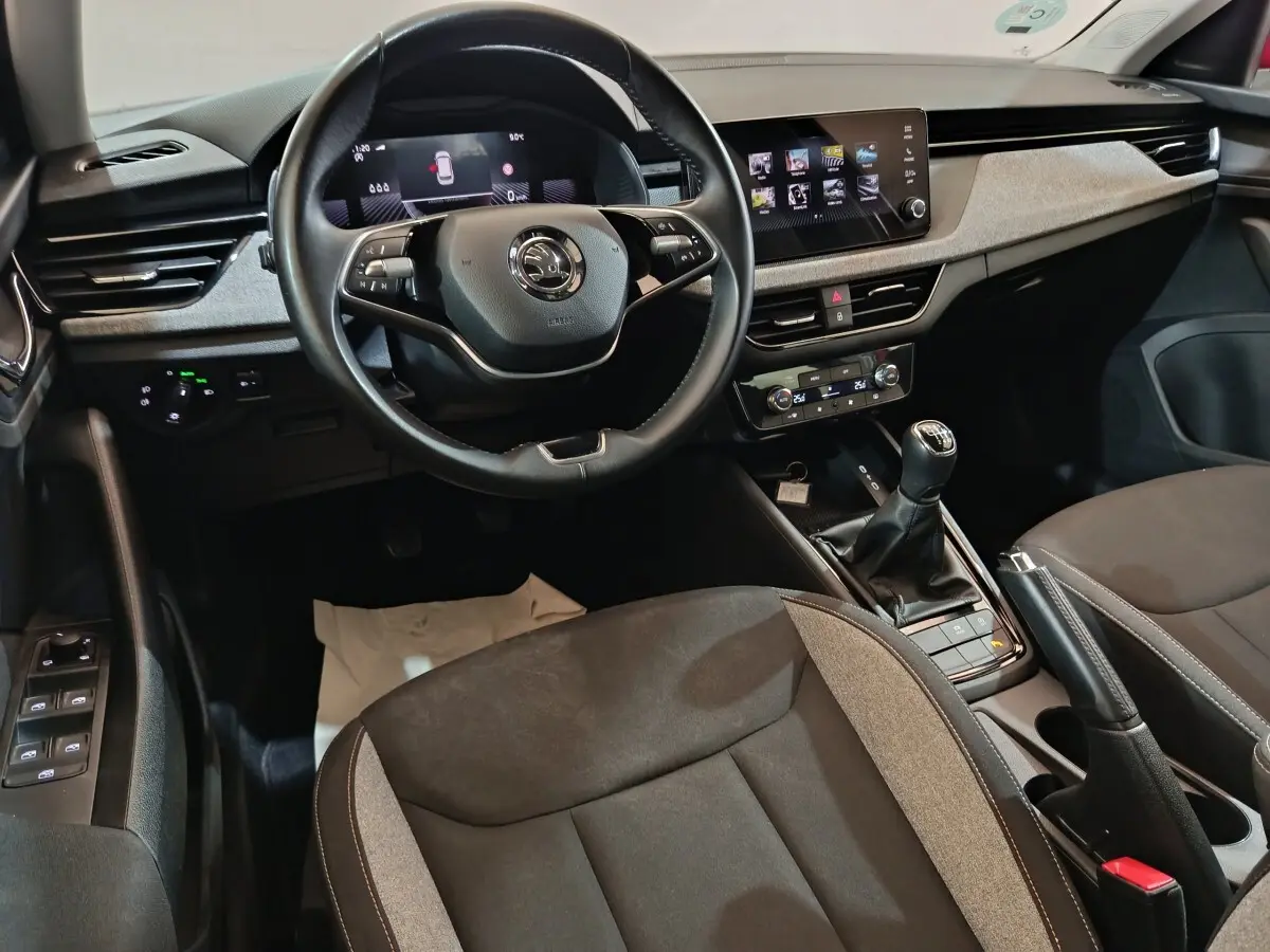 Vue intérieure avant du Skoda Kamiq 2024, volant cuir multifonctions, écran tactile central et levier de vitesses manuel.