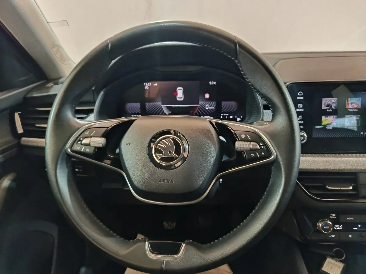 Volant cuir multifonctions de Skoda Kamiq 2024, vue frontale avec tableau de bord digital et écran tactile central.