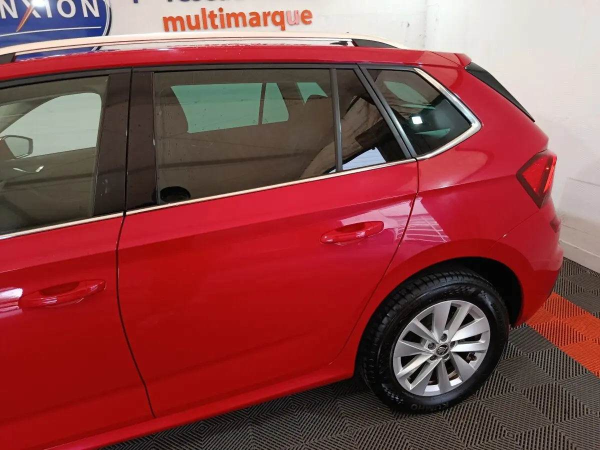 Vue latérale côté droit du Skoda Kamiq rouge 2024, mettant en valeur les vitres teintées et les jantes alliage.