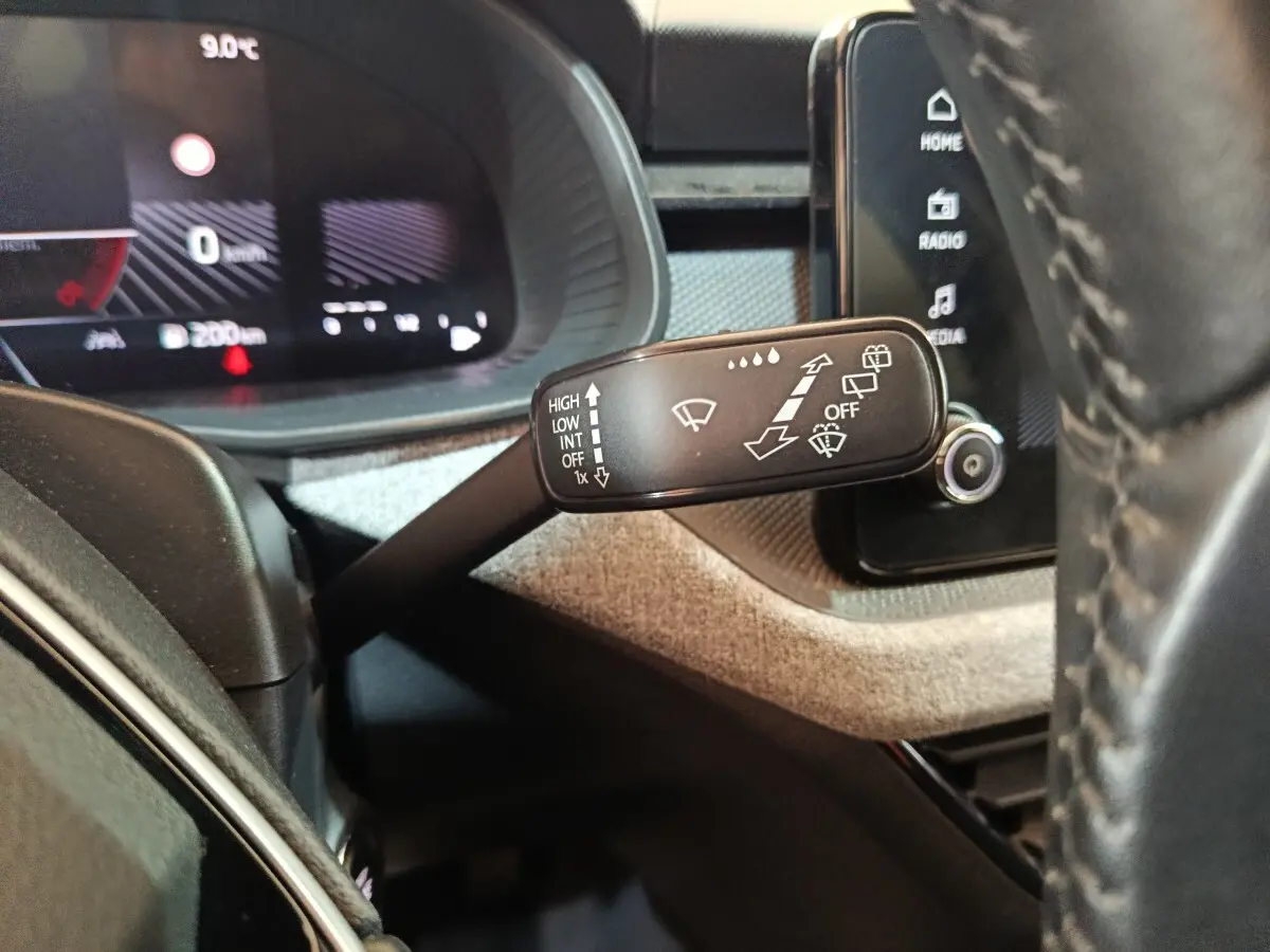 Gros plan sur la manette d’essuie-glace côté gauche du tableau de bord du Skoda Kamiq 2024 rouge avec affichage digital.