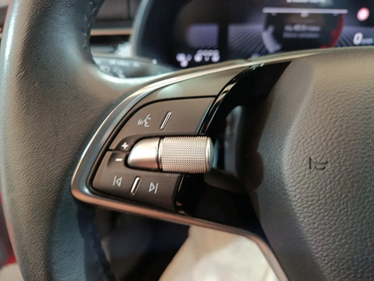 Gros plan sur le volant cuir multifonctions noir du Skoda Kamiq 2024, avec molette de réglage et commandes intégrées.