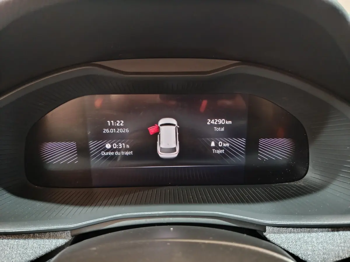 Affichage numérique du tableau de bord du Skoda Kamiq rouge, montrant l'alerte porte ouverte côté gauche.