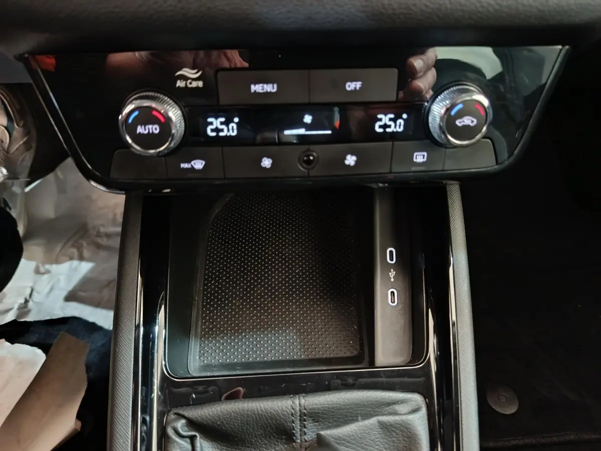 Vue rapprochée de la console centrale noire avec commandes climatisation digitale et ports USB du Skoda Kamiq 2024.