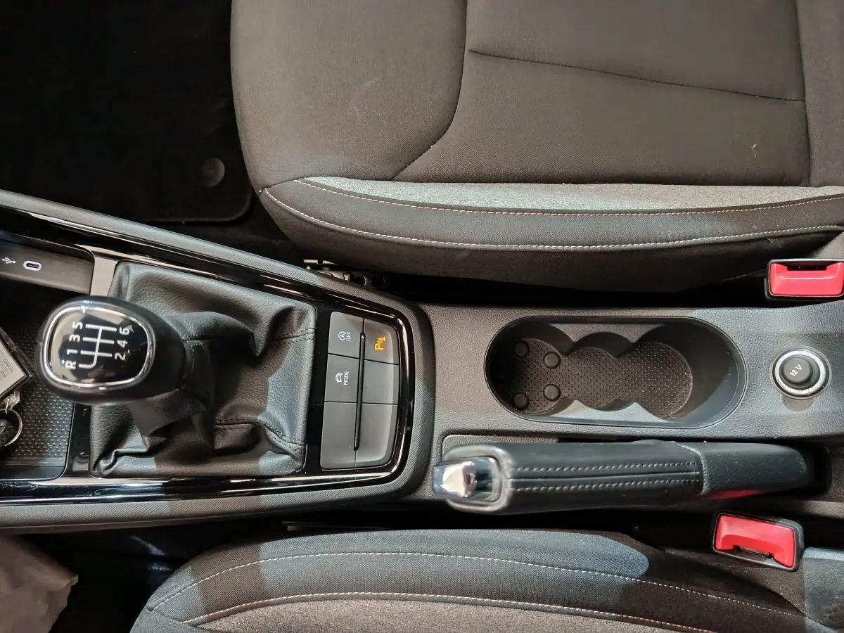 Vue plongeante sur la console centrale noire du Skoda Kamiq 2024 avec levier de vitesse manuel et frein à main cuir.