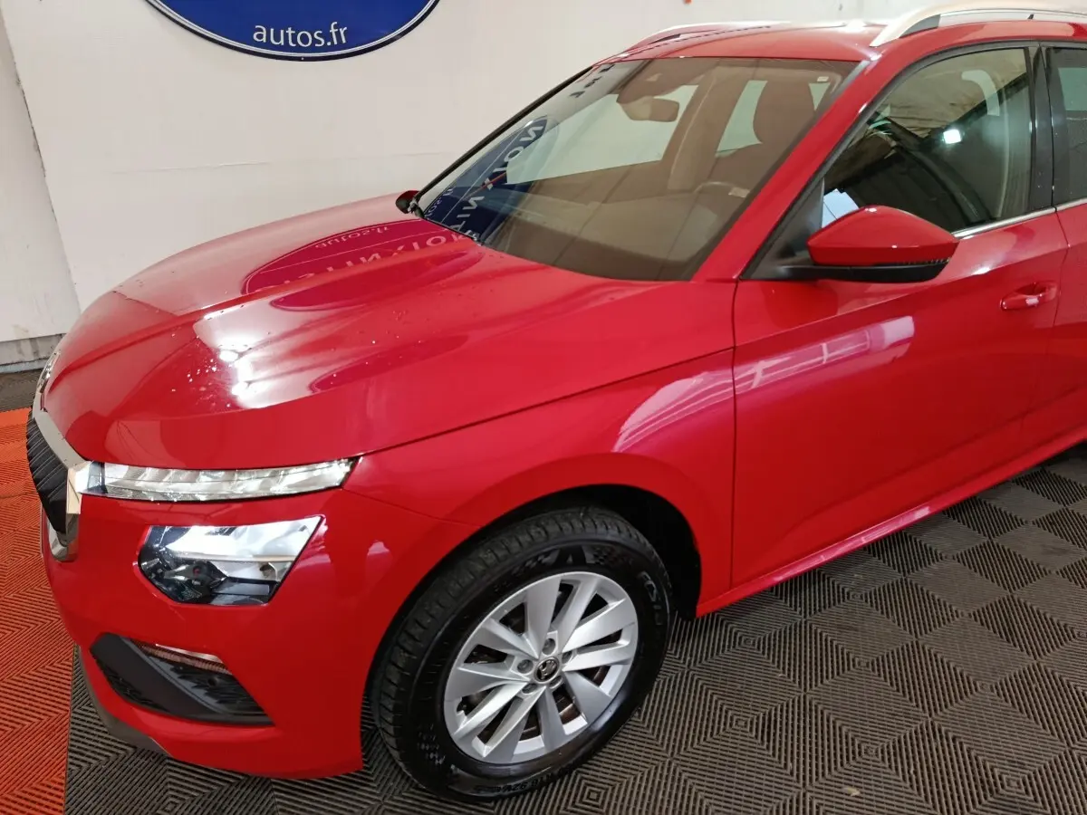 Vue 3/4 avant droit d'un Skoda Kamiq rouge 2024 avec phares LED et jantes alliage argentées.