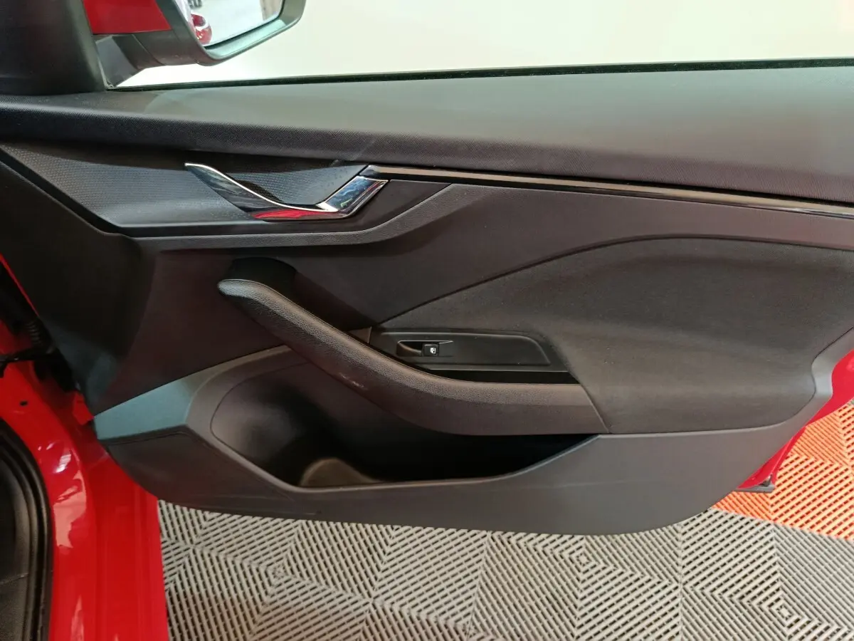 Vue rapprochée de la porte avant gauche noire avec poignée intégrée d’un Skoda Kamiq rouge 2024.