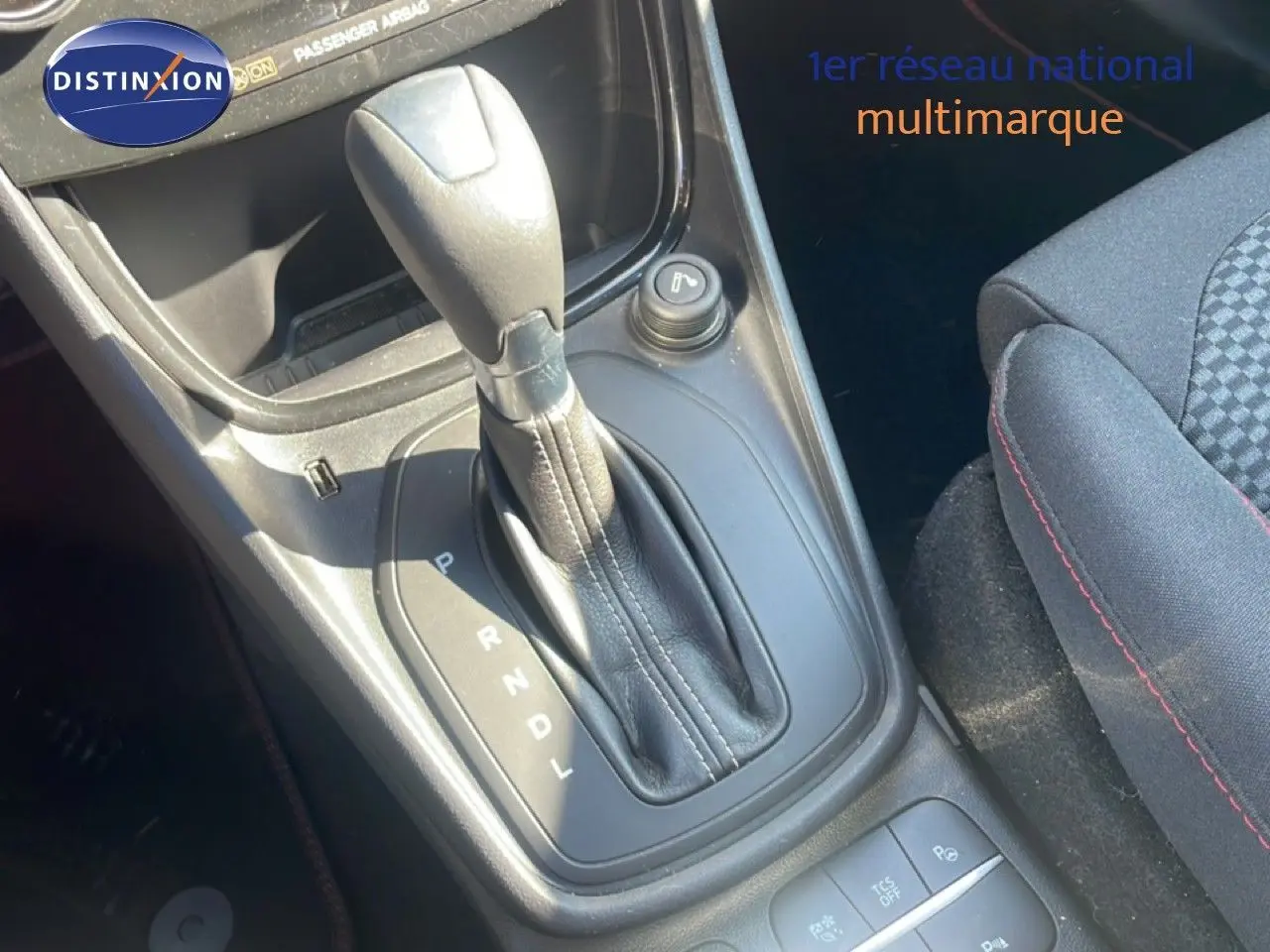 Gros plan sur la console centrale du Ford Puma gris Solar Metal, mettant en valeur le levier de vitesse automatique et les boutons de commande.