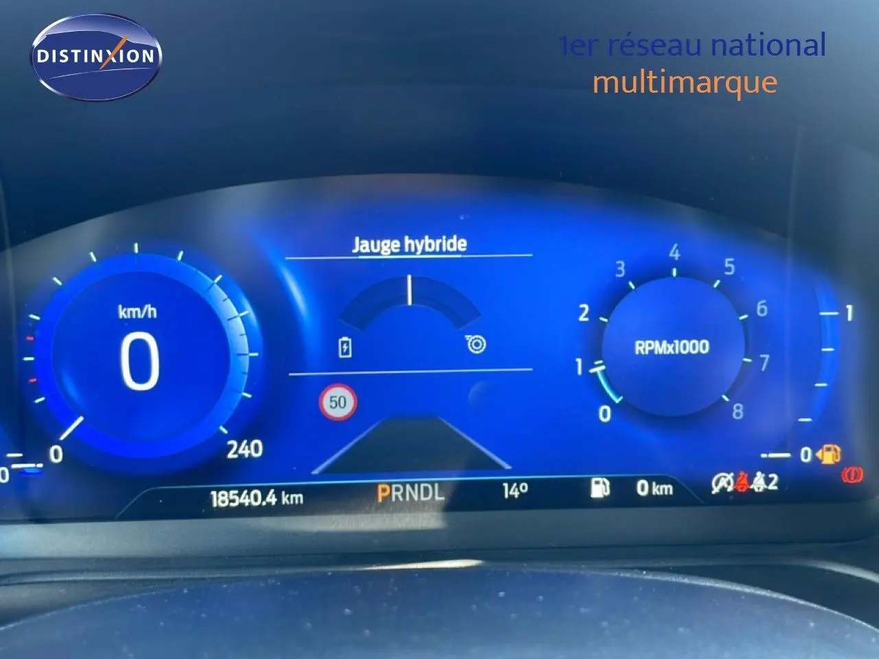 Tableau de bord numérique bleu du Ford Puma 2023, affichant vitesse, compte-tours et jauge hybride.