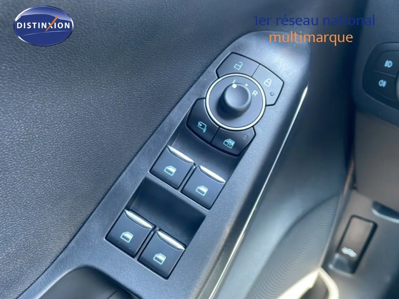 Vue rapprochée des commandes de lève-vitres et rétroviseurs sur la porte côté conducteur d’un Ford Puma gris Solar Metal.