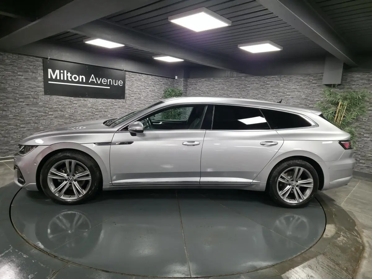 Volkswagen Arteon Shooting Brake gris métallisé vue de profil côté gauche en intérieur avec jantes alliage 18 pouces.