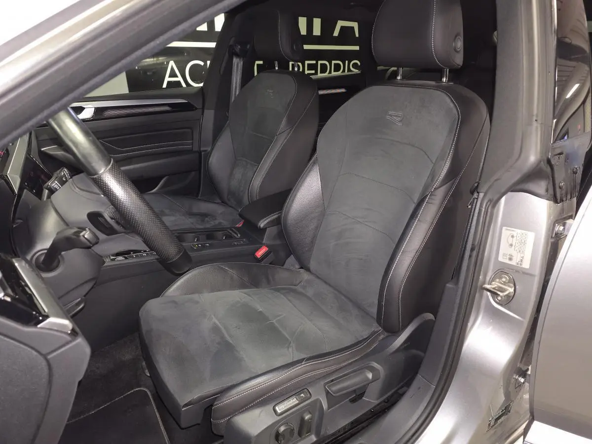 Vue intérieure côté conducteur du Volkswagen Arteon gris 2022, sièges sport en cuir et microfibre avec logo R brodé.