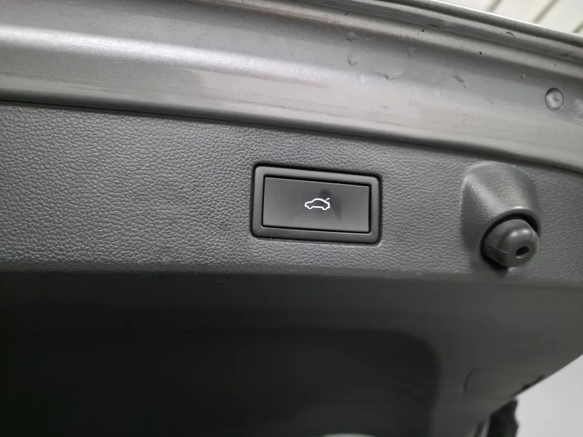 Bouton de déverrouillage électrique du hayon sur le coffre intérieur d’un Volkswagen Arteon gris Shooting Brake 2022.